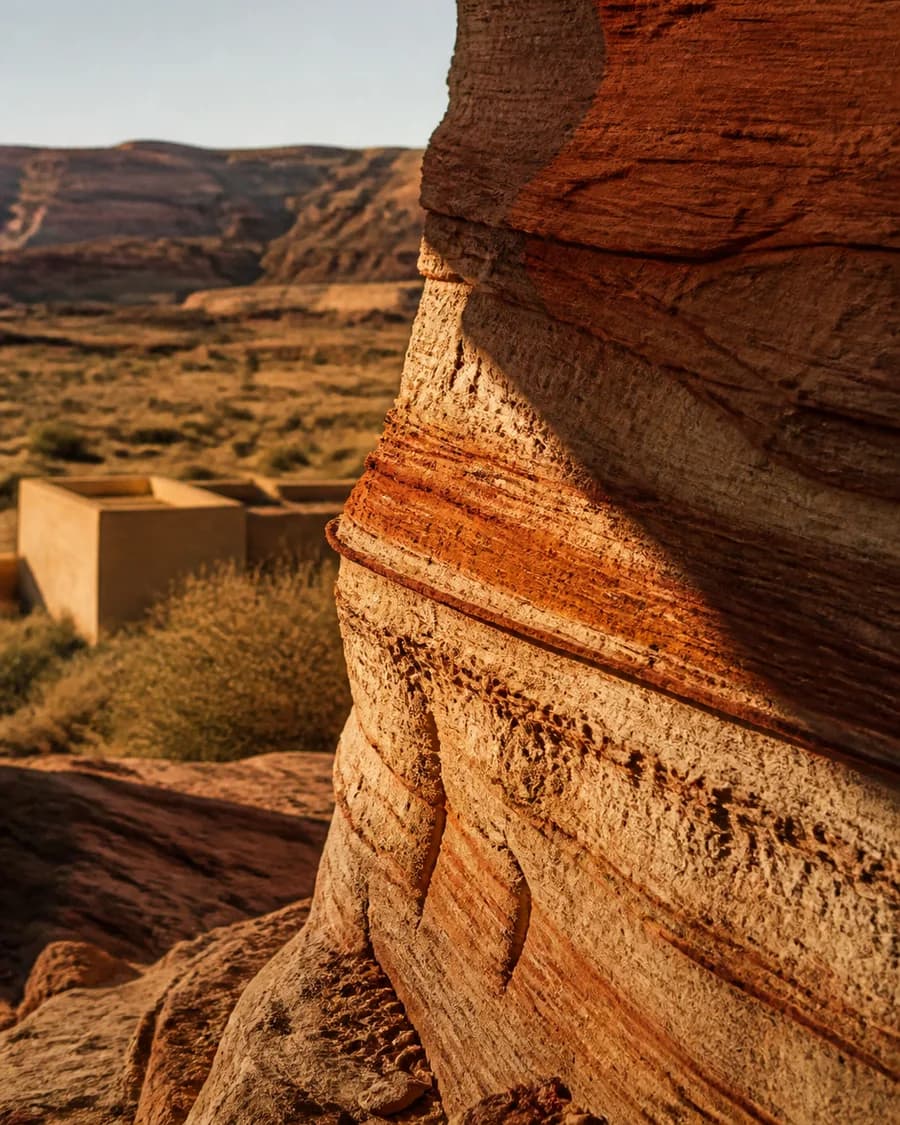 Layered sandstone strata in raking evening light, rust and cream bands